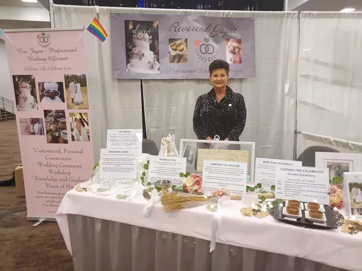 Reverend Jayne at a memorial display with photos, flowers and candles
