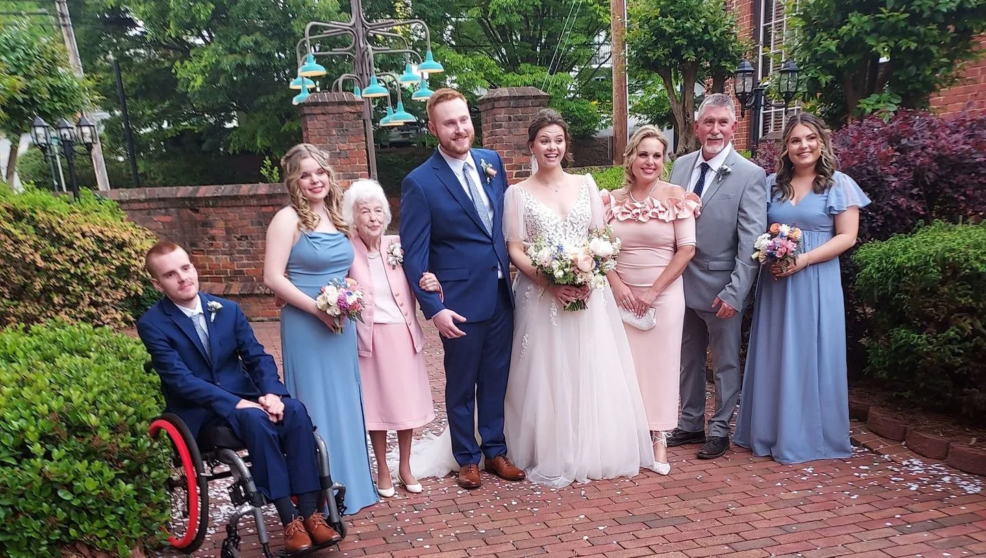 Wedding party posing outdoors with the bride holding a bouquet