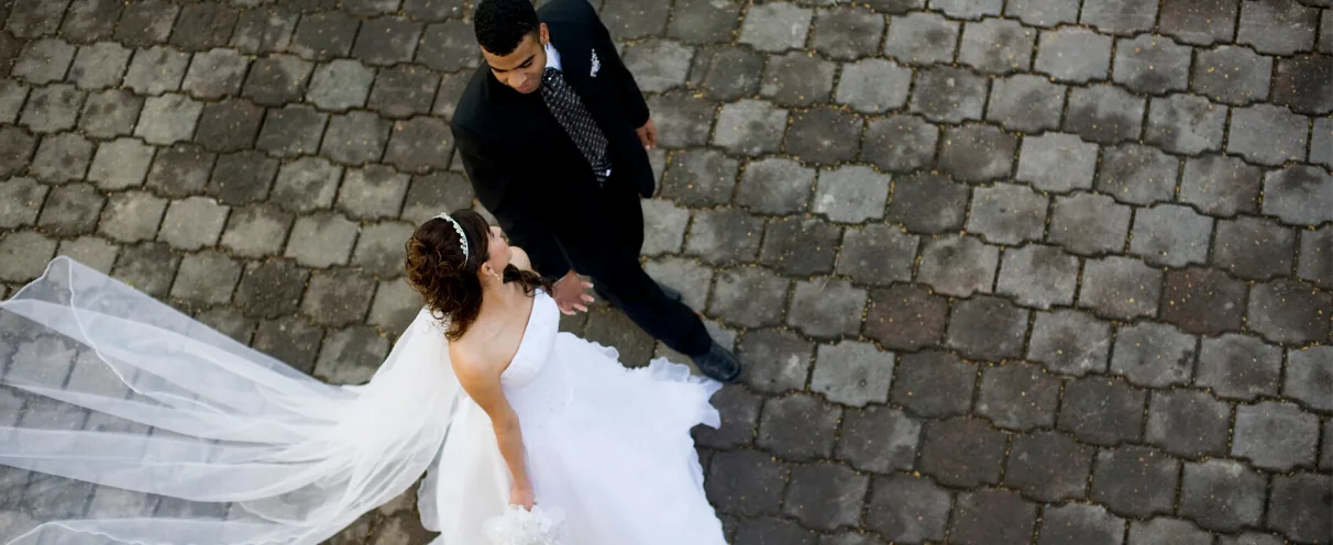 Bride and groom walking together, veil flowing