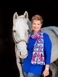 Reverend Jayne standing beside her white horse